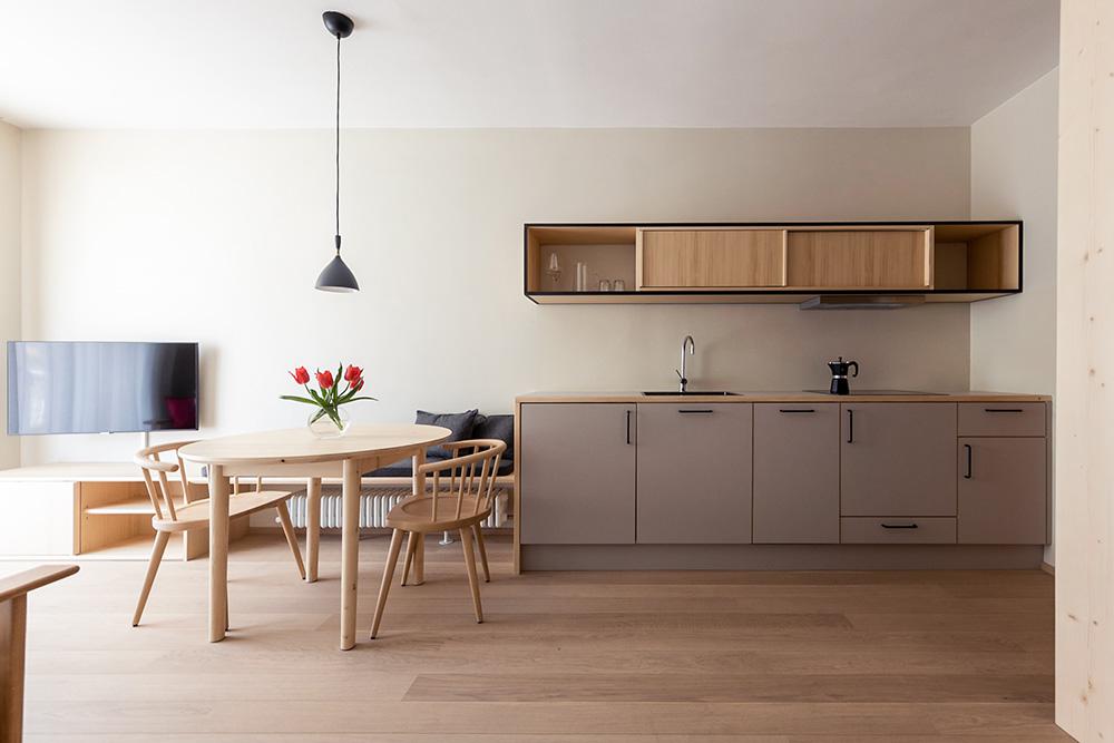 Offene Küche mit Esstisch und Holzstühlen in moderner Ferienwohnung Lana Stadtzentrum